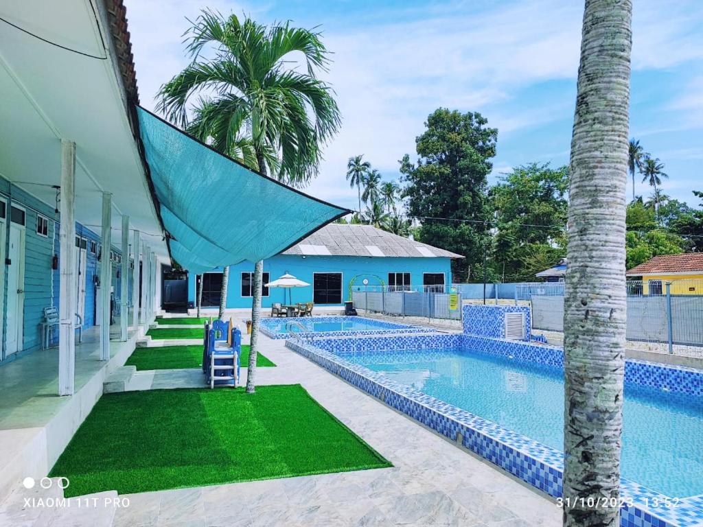 士兆Green Forest Resort的一座房子旁的游泳池,里面种着棕榈树