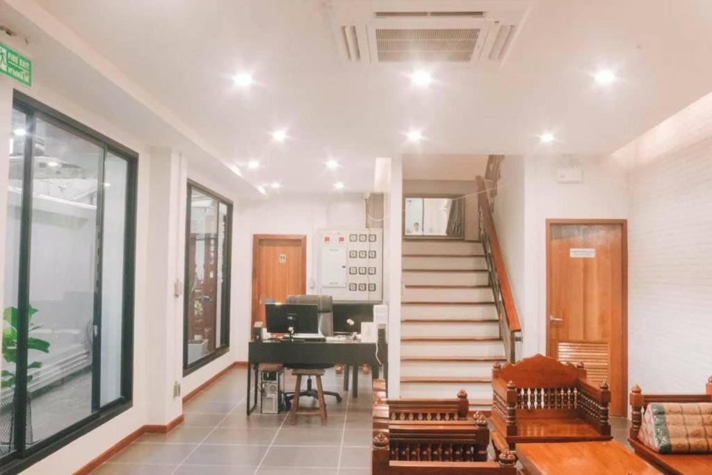 曼谷Jira19Hostel的客厅设有楼梯和钢琴