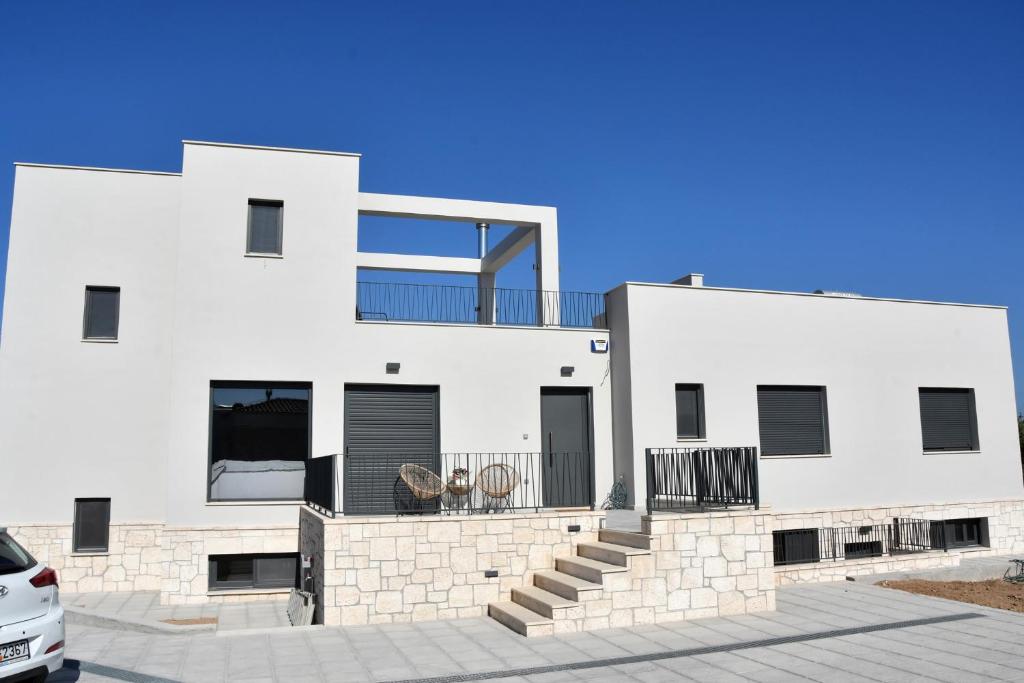 爱琴娜岛Polles Εlies Cozy Αpartment的白色房子的一侧设有阳台