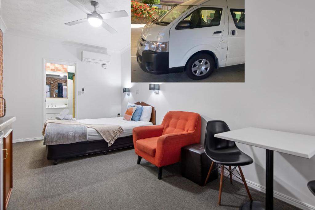布里斯班克莱菲尔德机场汽车旅馆的卧室配有一张床,墙上装有白色面包车