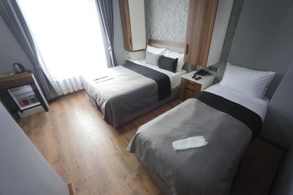 伊斯坦布尔Yuvam akmarmara hotel的酒店客房设有两张床和窗户。