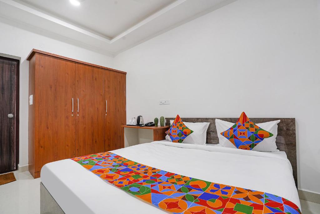 海得拉巴FabHotel Rooms 27的一间卧室配有一张床和一个木制橱柜