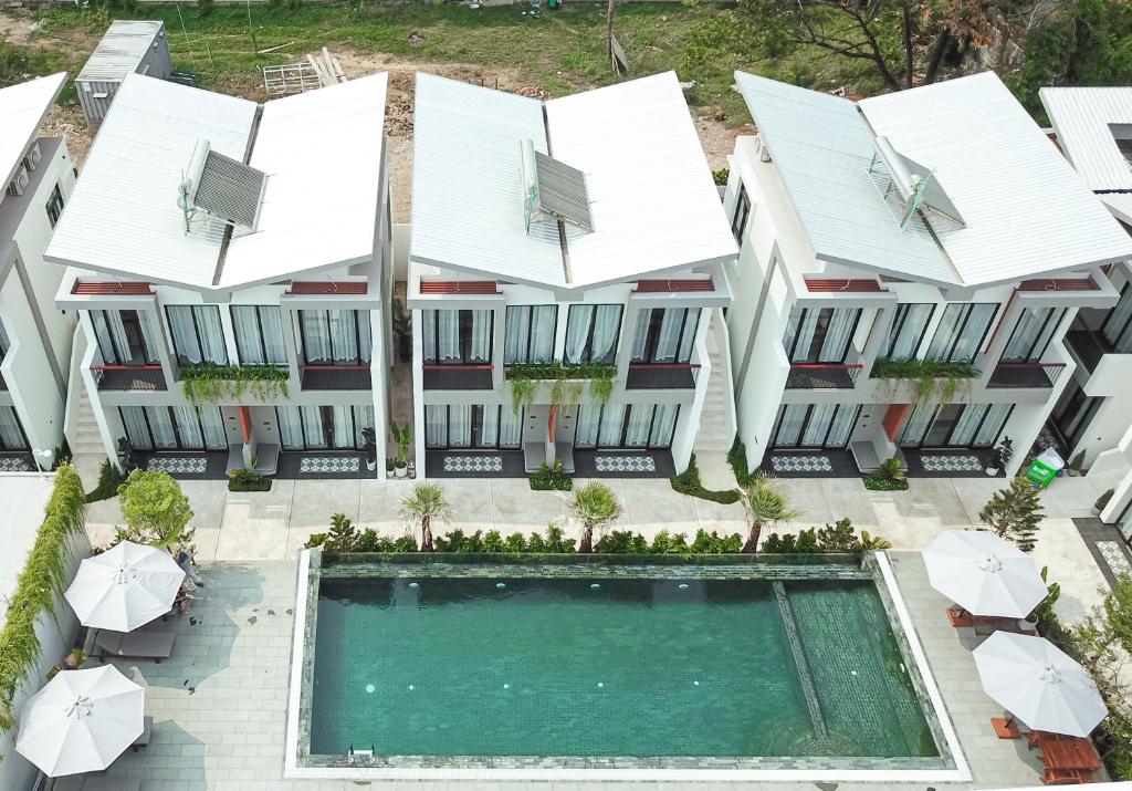 贡布Emerald Residence Kampot的享有带游泳池和遮阳伞的建筑的空中景致