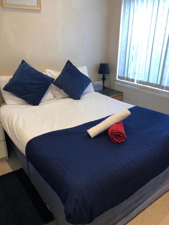 利物浦Great Apartman Liverpool的一张带蓝色和白色床单及蓝色枕头的床