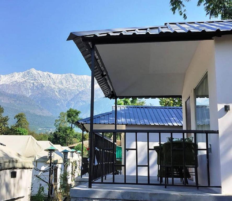 达兰萨拉Dev Bhoomi Farms & Cottages的一座带太阳能屋顶的山地房屋