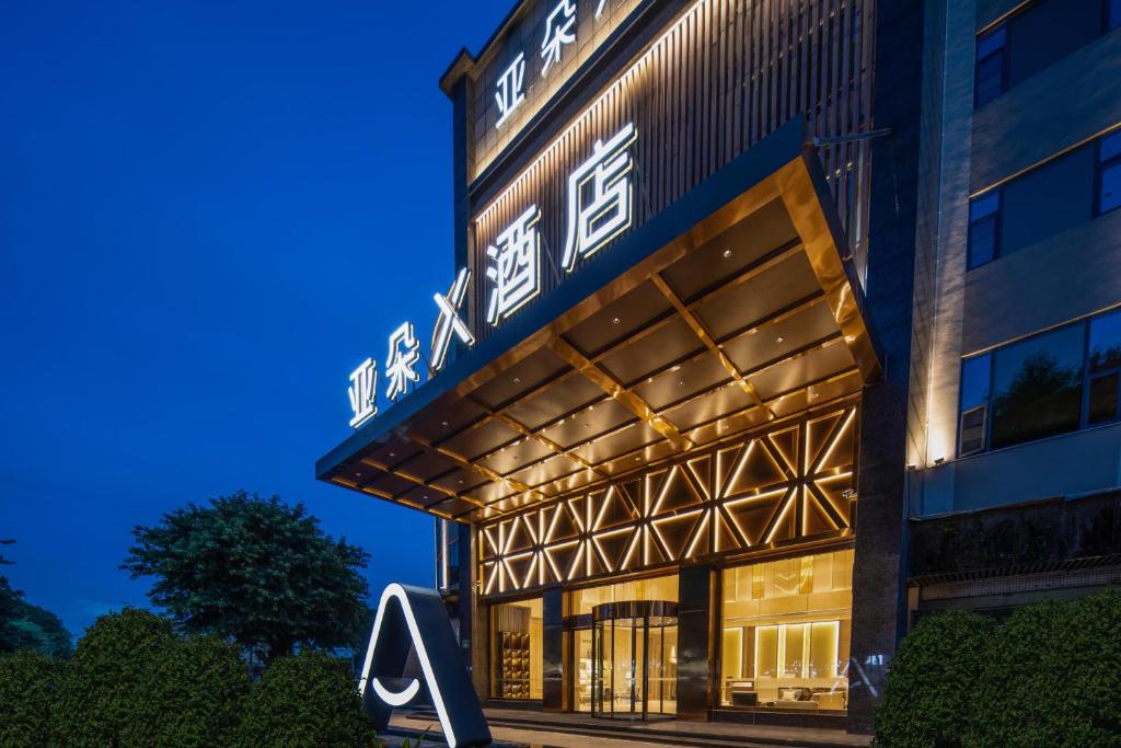 广州广州白云国际机场人和地铁站亚朵X酒店的夜间建筑物前部的 ⁇ 染