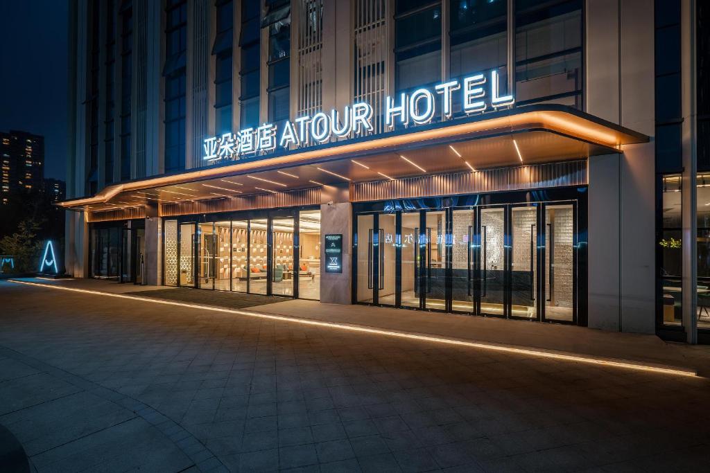 成都成都东站绿地468中心亚朵酒店的夜间标有标志的酒店大楼