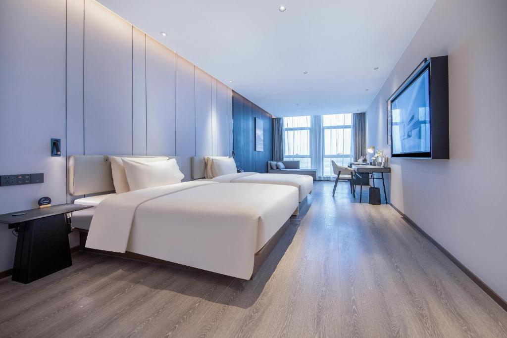 济南济南华山环宇城亚朵酒店的酒店客房设有两张床和电视。