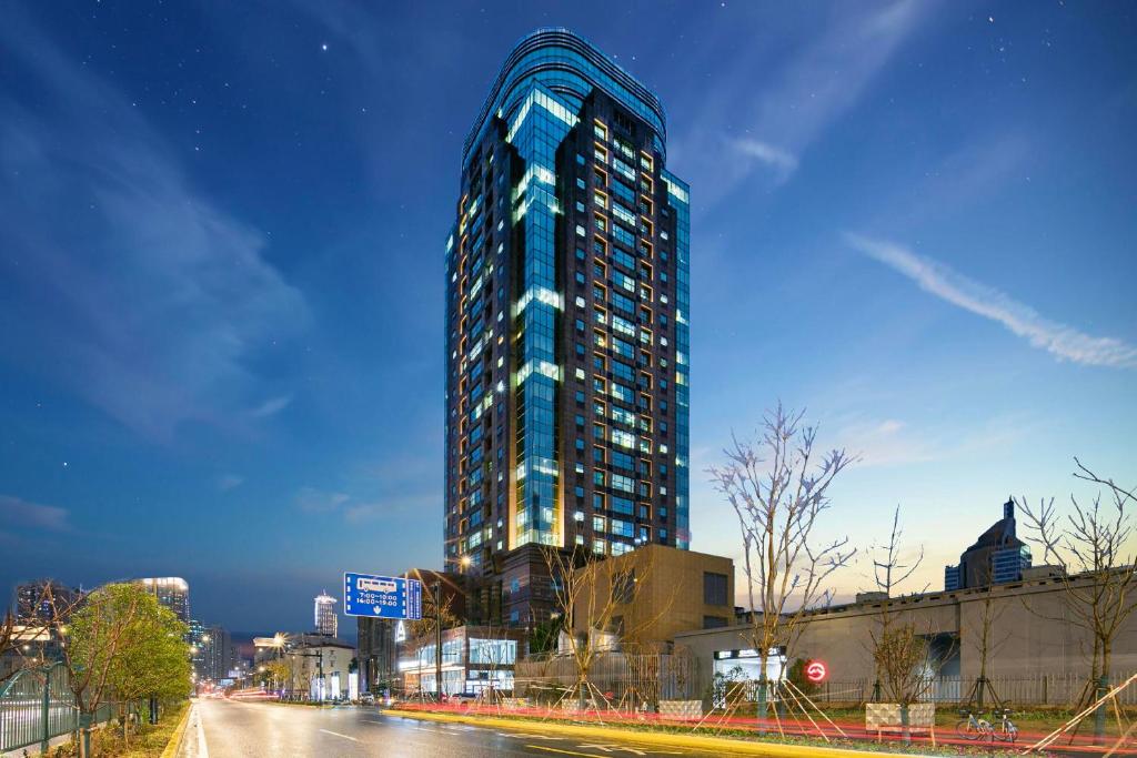 上海上海陆家嘴浦东大道亚朵酒店的夜幕降临的城市街道上一座高大的蓝色建筑