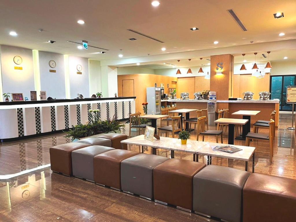 台南台南圣旺商旅的一间带长椅和桌子的餐厅以及一间酒吧