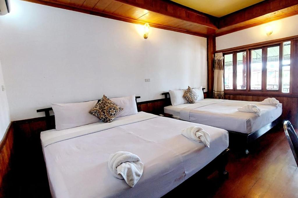 Ban KhonBontai Resort, Don Khon的配有2张床的白色墙壁和窗户客房