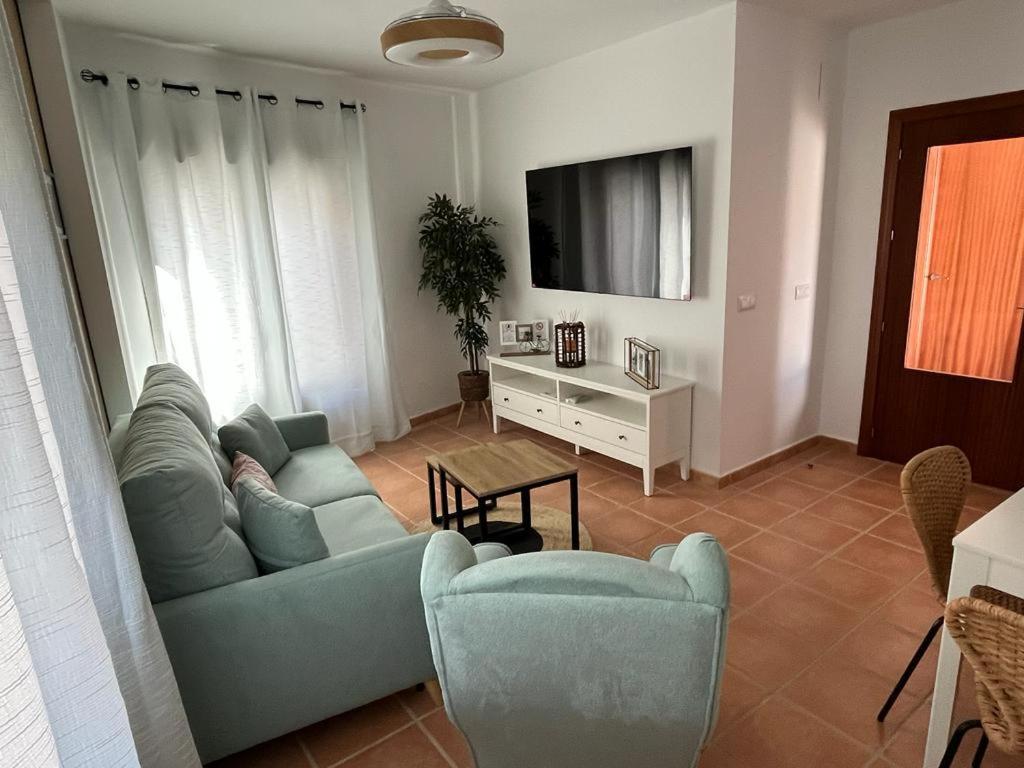丰特埃里多斯El Balcón de Fuenteheridos的客厅配有沙发、椅子和电视
