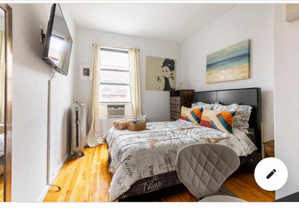 纽约Deluxe Manhattan room的一间卧室配有一张床和一台电视