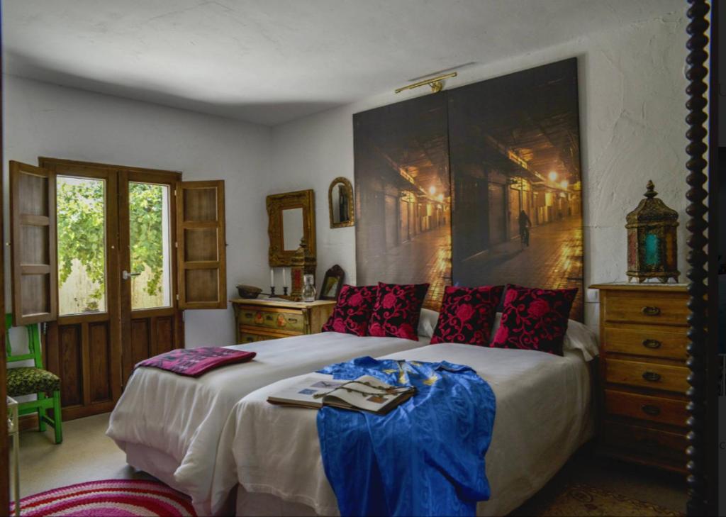 Torremocha de JaramaLos Diezmos的一间卧室配有一张大床,墙上挂着一幅大画