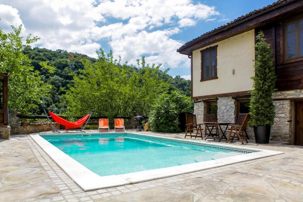 大特尔诺沃Veliko Tarnovo Villa Lora的一个带椅子的游泳池以及一座房子