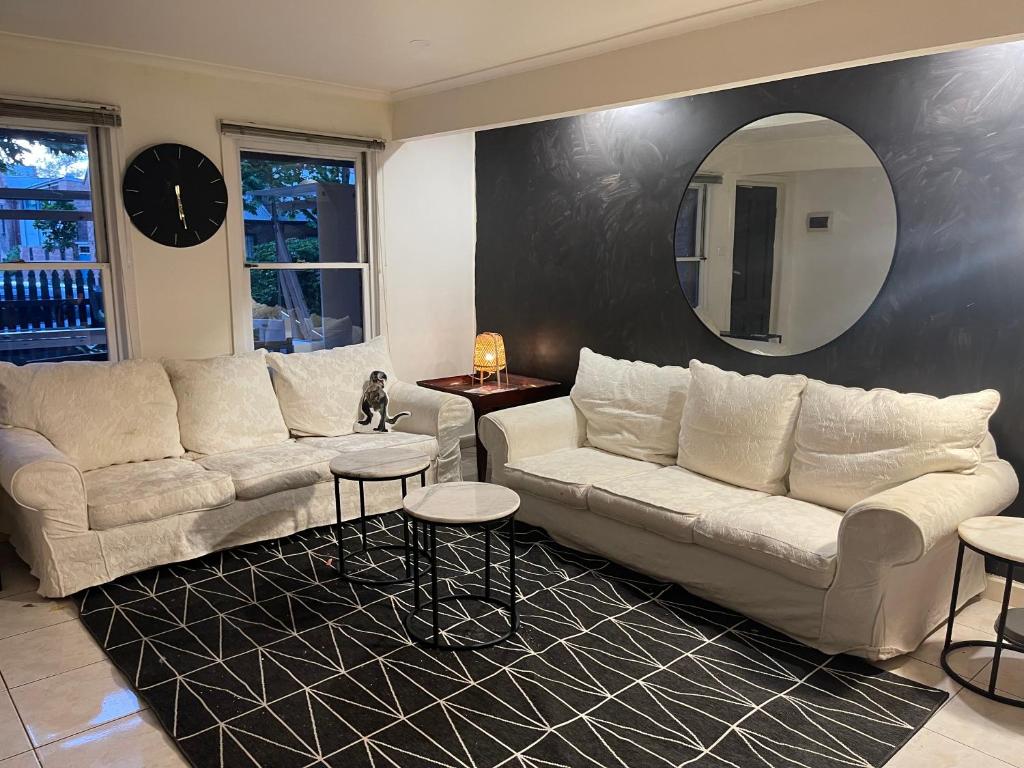 墨尔本Luxury Fitzroy House的客厅配有两张沙发和一面镜子