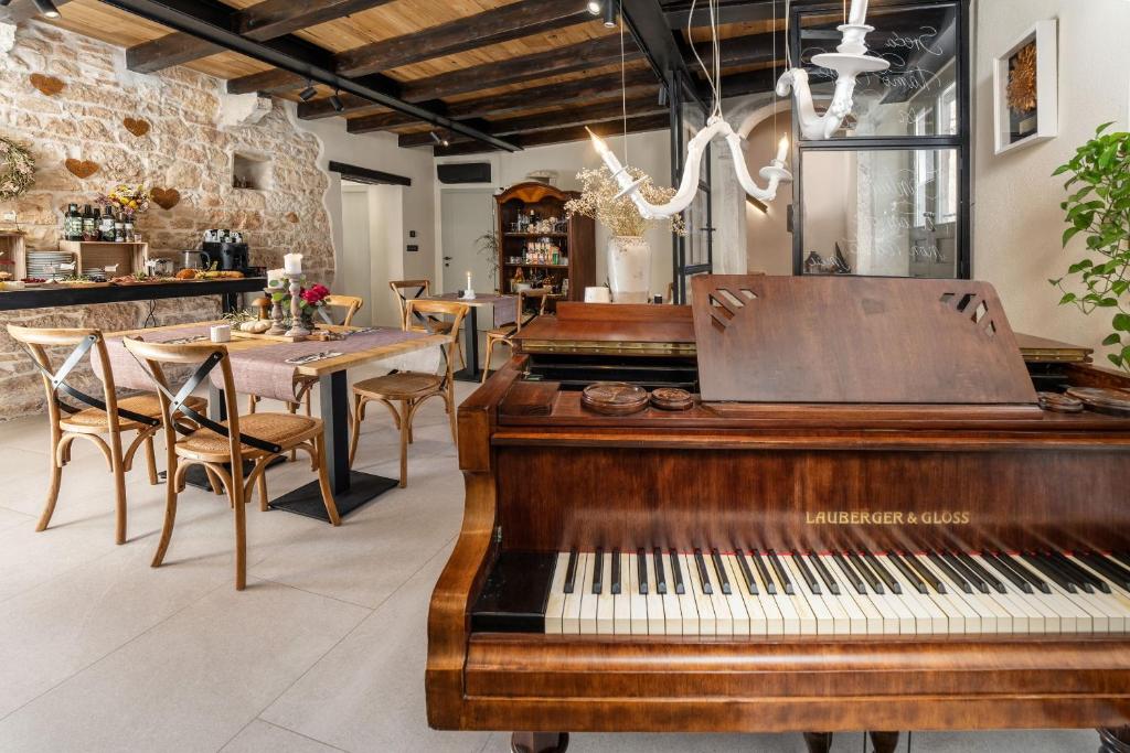 斯维特温斯纳特Della Croce Bed&Breakfast的餐厅的钢琴,配有桌椅