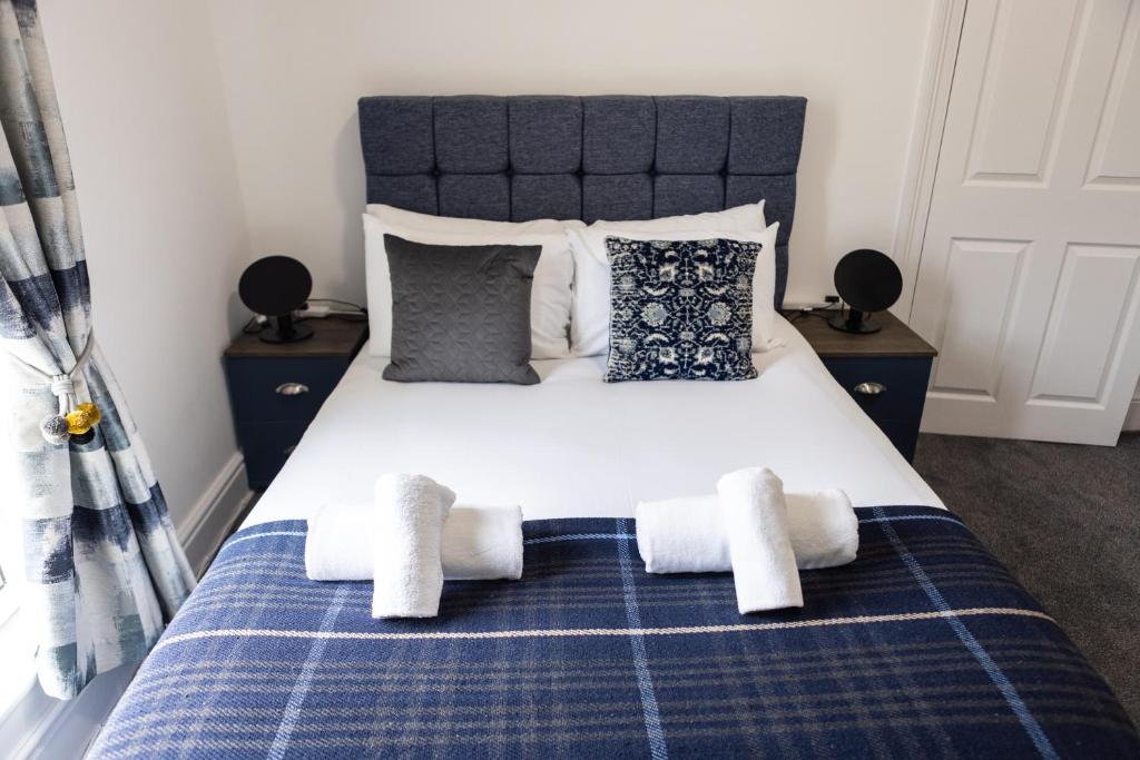 普里茅斯Fred's Place的卧室配有蓝色和白色的床,提供毛巾