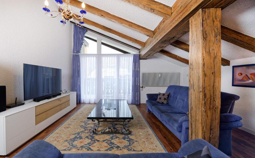 采尔马特豪斯艾米娜酒店的客厅配有蓝色的沙发和电视