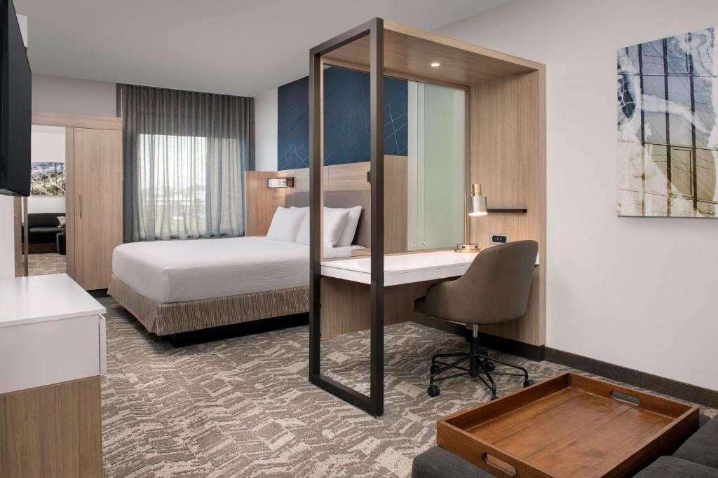 梅森SpringHill Suites by Marriott Cincinnati Mason的酒店客房配有一张床和一张带镜子的书桌
