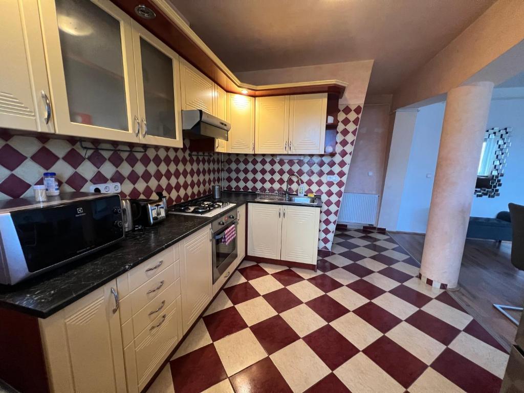 塞格德Kristály Apartman的厨房配有白色橱柜和 ⁇ 格地板