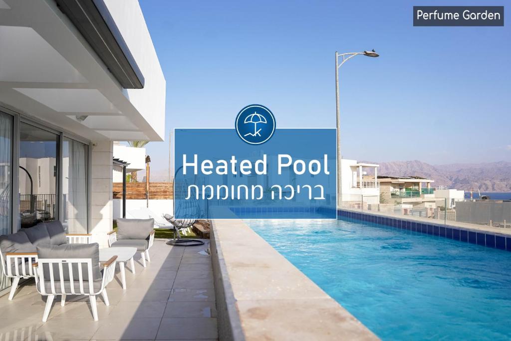 埃拉特YalaRent Mountainside Luxury apartments with Private Pool的一个带椅子的酒店游泳池,以及一个阅读莫罗尼公里温水游泳池的标志
