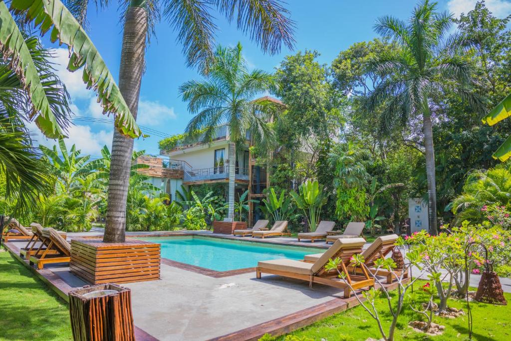 图卢姆埃克斯卡普图论酒店的一座别墅,设有游泳池和棕榈树