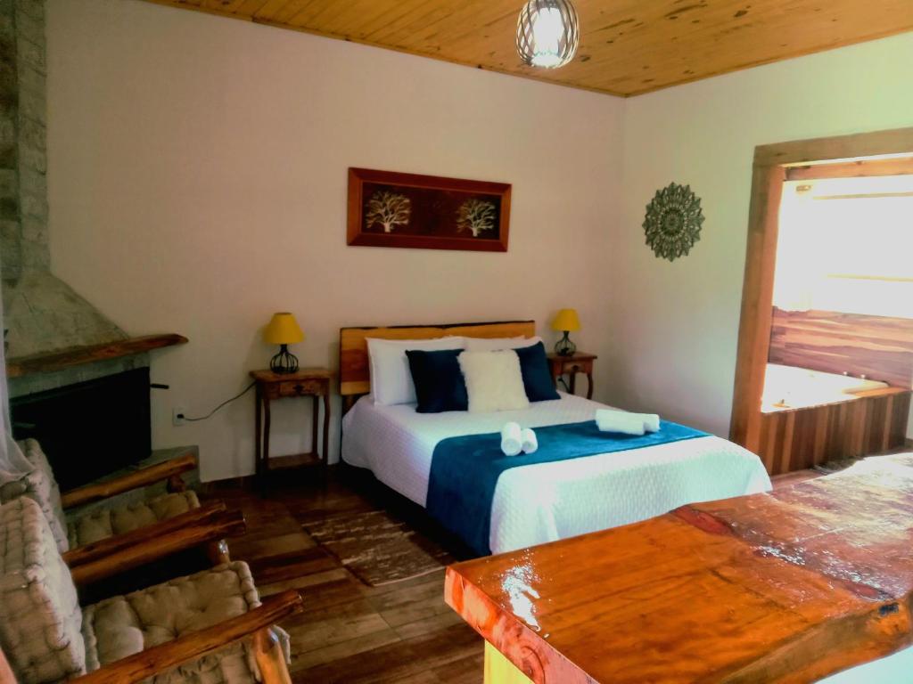 维奥康德马奥Recanto KAIRÓS的一间卧室设有一张大床和一个壁炉