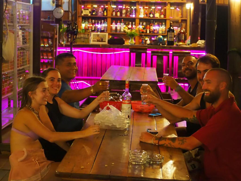瓜隆岛Coconutbeach Bungalows Party Hostel的一群坐在酒吧桌子上的人