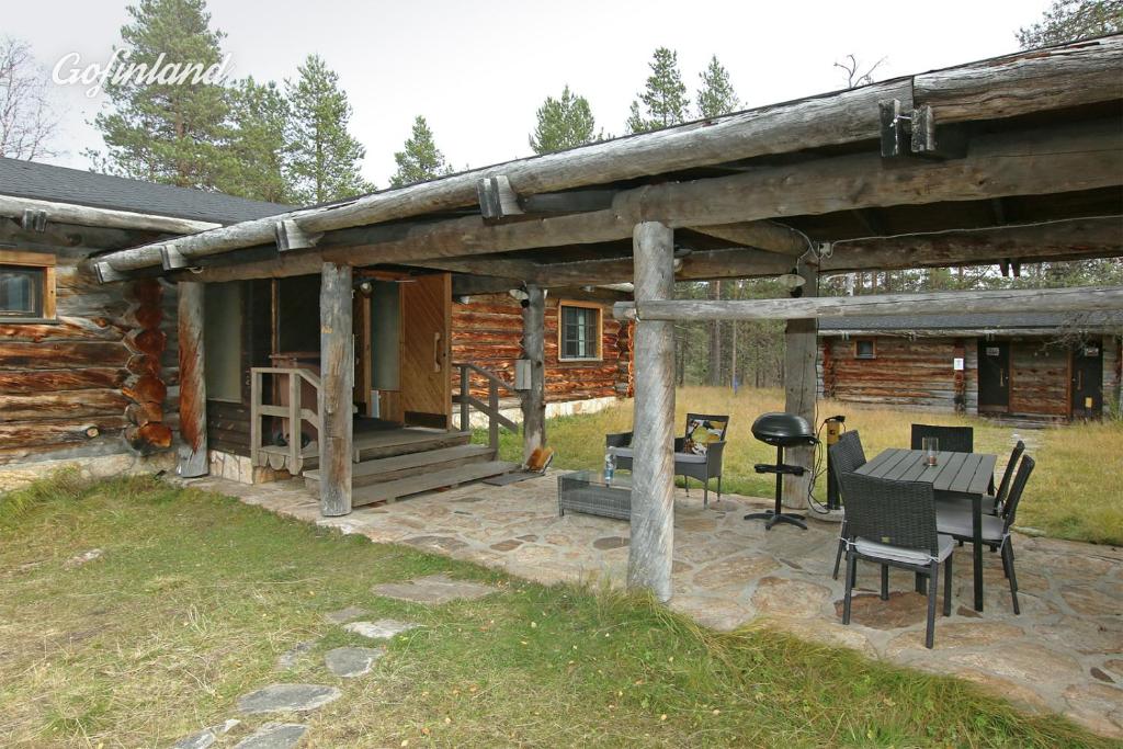 萨利色尔卡Kuukkeli Log Houses Porakka Inn的小木屋外的天井,配有桌椅