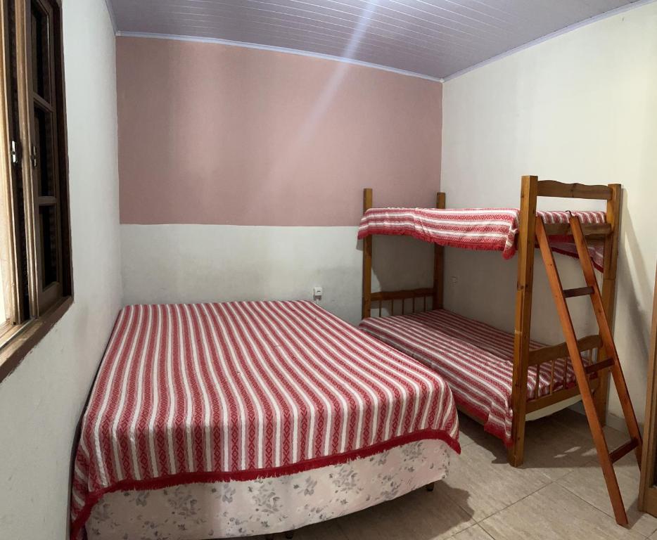卡波布里奥Kitnet em Cabo Frio 04的一间卧室设有两张双层床和梯子