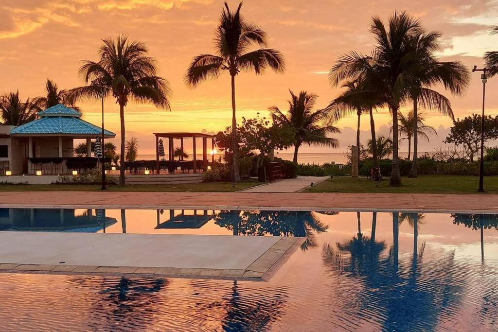 普拉亚卡门MAREAZUL Beachfront Apartment 2BR Private Pool Casa Áncora的棕榈树游泳池和凉亭