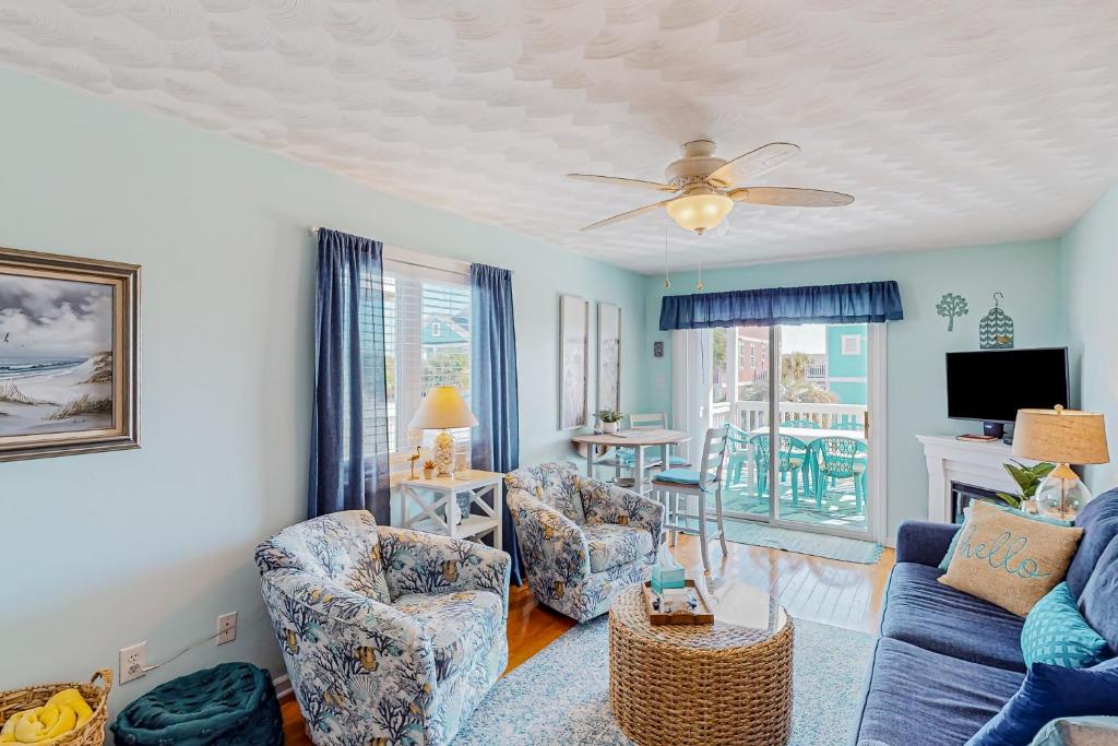 霍尔顿海滩Captain's Villa 9-C Sunshine Ally的客厅配有沙发、椅子和电视