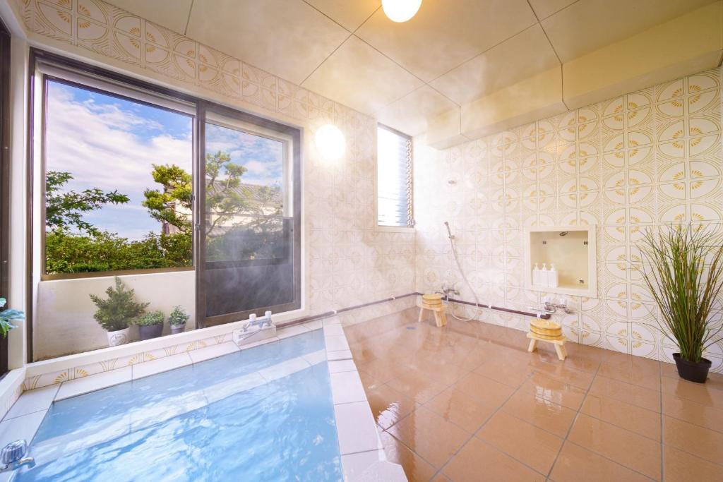 别府Kiseki no Aoi Tennenonsen - Vacation STAY 15697的一个带大窗户的房间内的游泳池