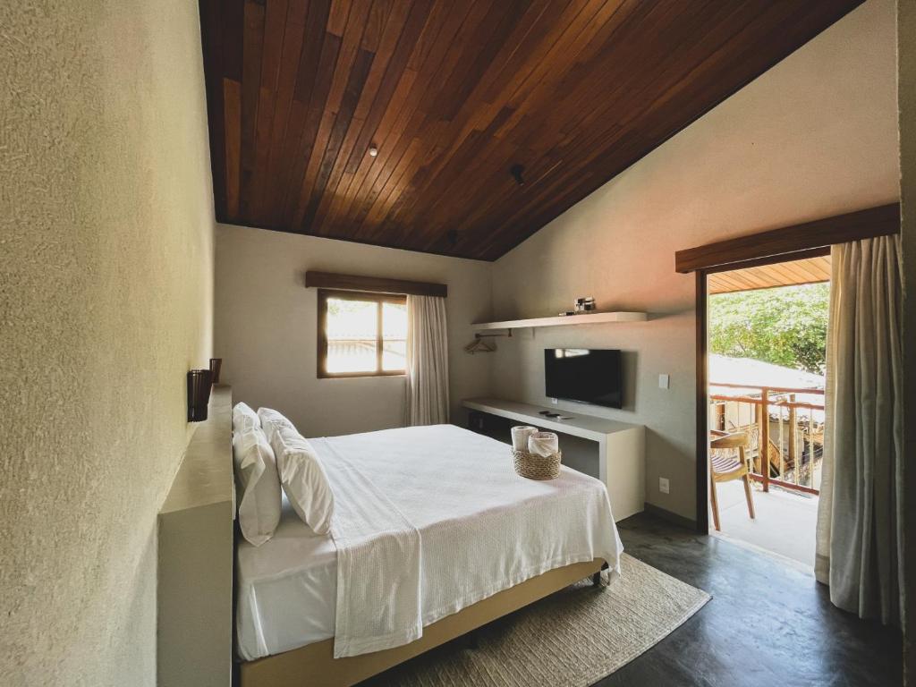 普拉亚多AL MAR SUÍTES的一间卧室设有一张木天花板床。