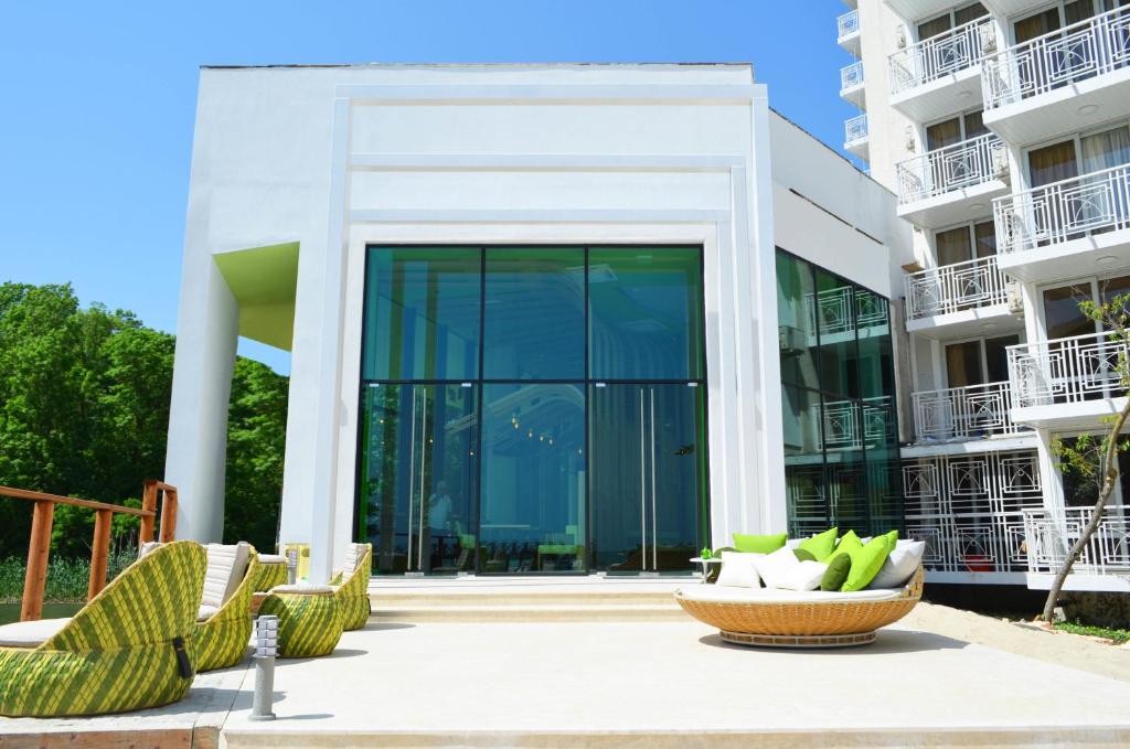 阿尔贝纳Hotel Gergana - Ultra All Inclusive的庭院内带玻璃门和椅子的建筑