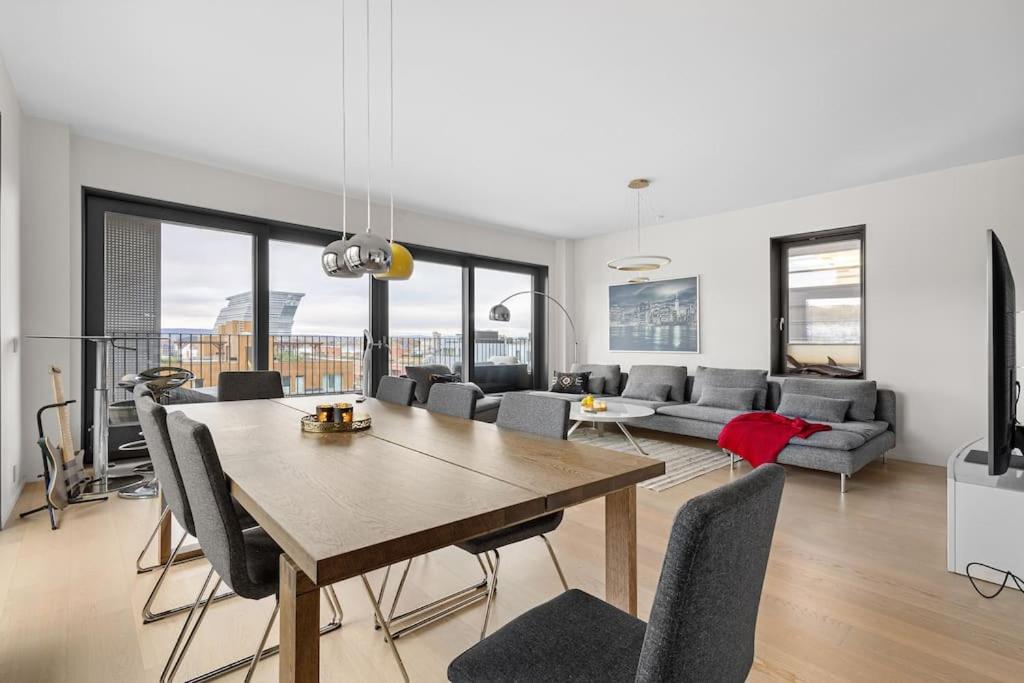 奥斯陆Modern 3bed room sea view apartment @ Oslo Barcode的客厅配有桌子和沙发