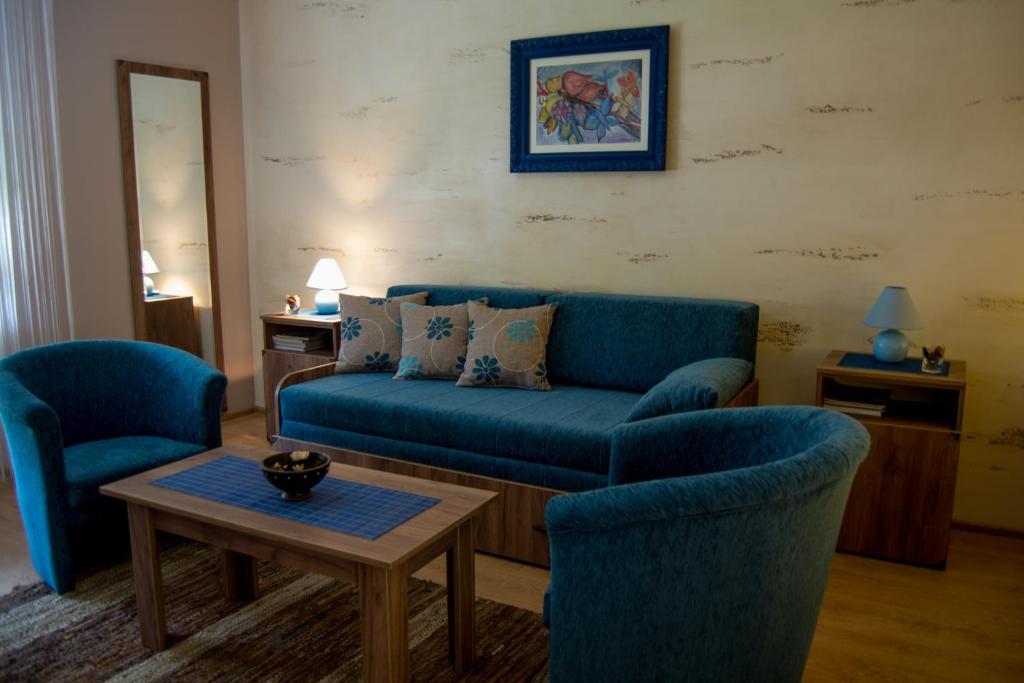 鲁马Guest House A'storia的客厅配有蓝色的沙发和两把椅子