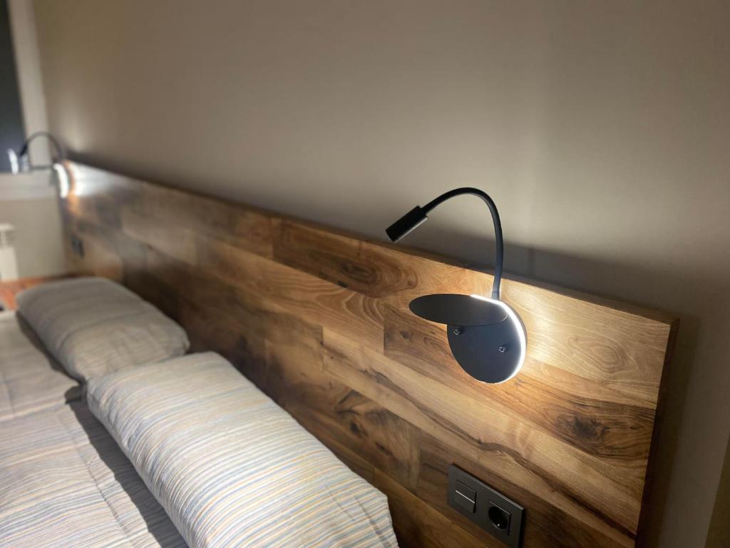卡尔多纳La Rotonda的一张带木床头板的床,上面有灯