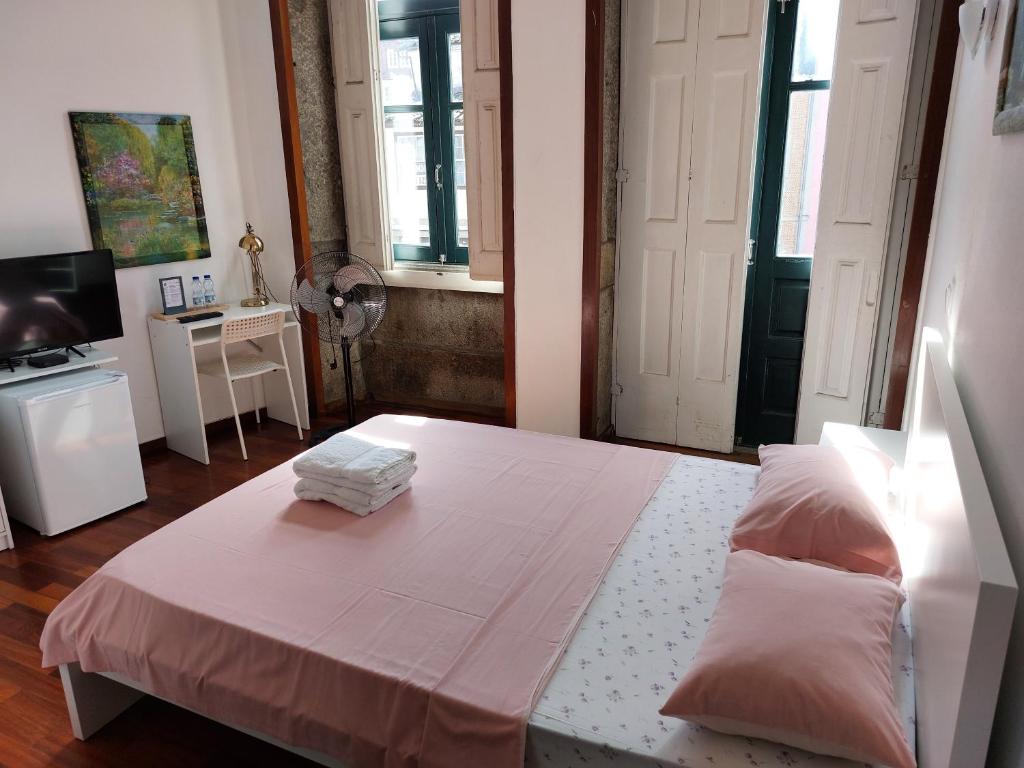 布拉加Guest House Sir Manuel - Unidade São Vicente的一间卧室设有一张床、一台电视和窗户。