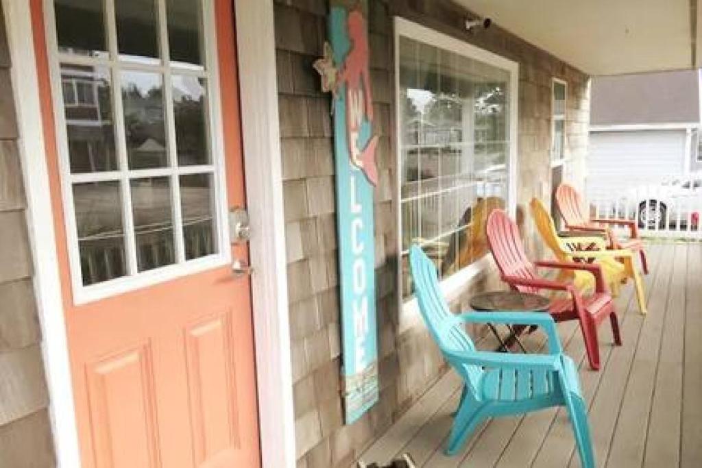 西塞德Seaside OR- Chic Family Beach Escape & Fast Wi-Fi的门廊,带五颜六色的椅子和门