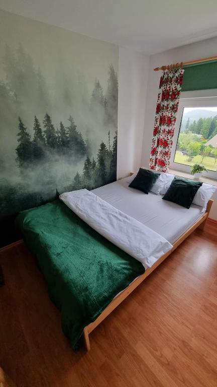 兹瓦尔东Góralski domek na szczycie的卧室内的一张床铺,墙上有绘画作品