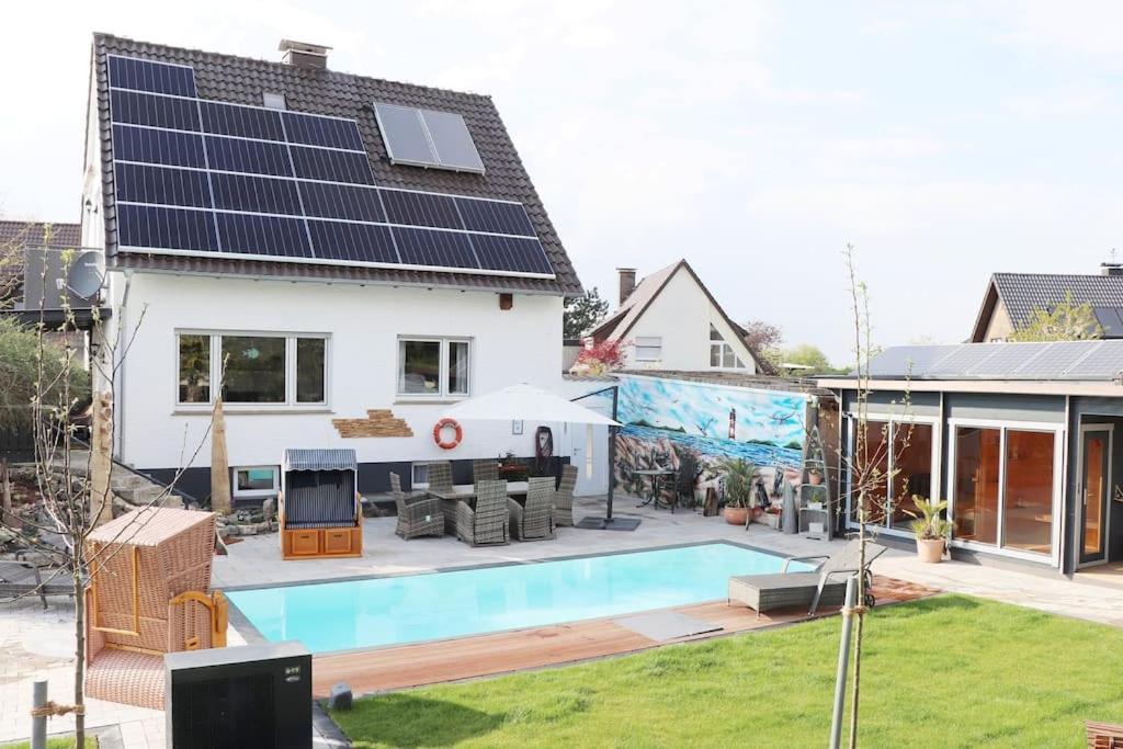 LageExklusive Dorfpension mit Pool und Sauna的一座房子,里面设有一座带太阳能电池板的游泳池