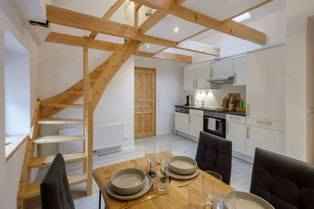 布克斯泰胡德Exklusives Tiny House in Elbnähe的厨房以及带木桌和椅子的用餐室。