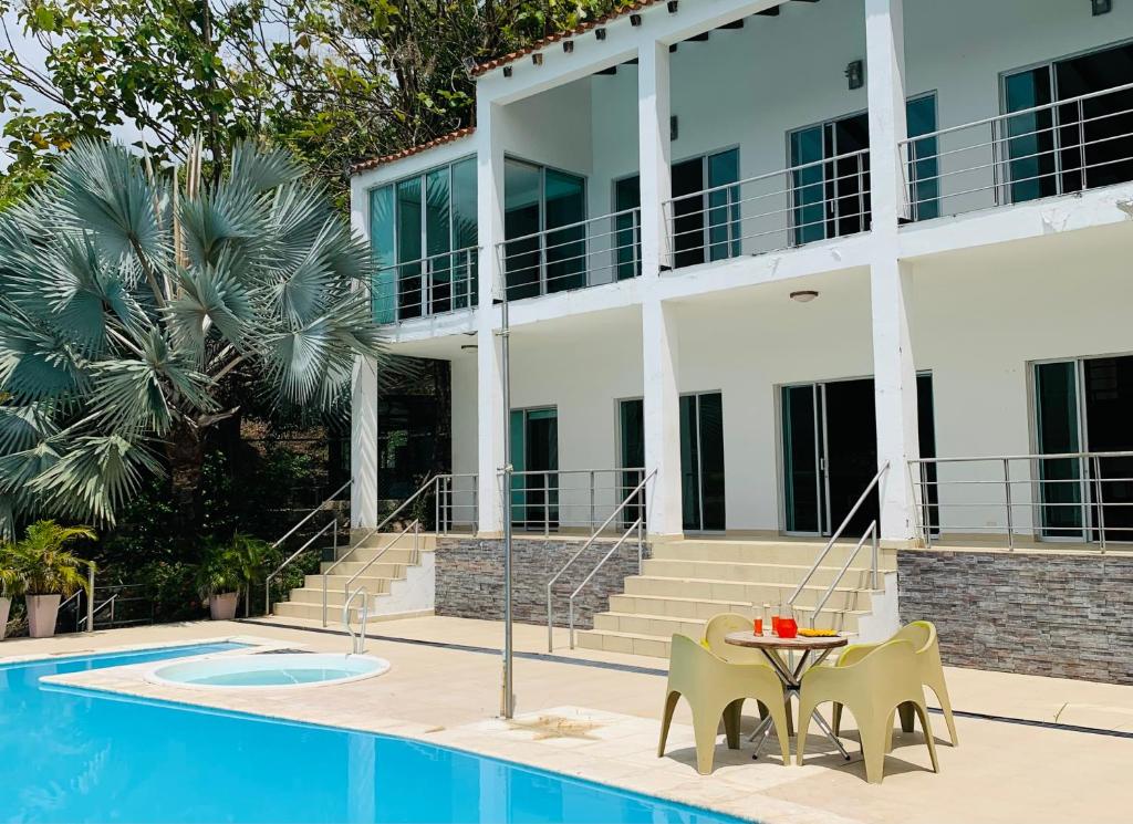 普拉多Isla Privada al interior de Colombia en Prado Tolima的游泳池旁的酒店设有桌椅