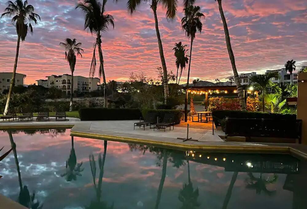 圣何塞德尔卡沃TiMÓN 107 Condo 2 bedrooms in San Jose del Cabo.的棕榈树泳池和日落背景