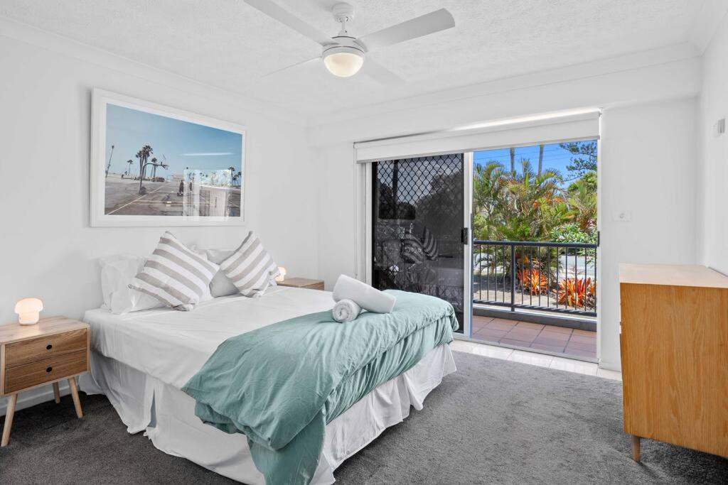 黄金海岸Bilinga Beach House的白色的卧室设有床和大窗户