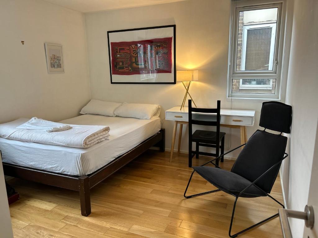 伦敦No-taking-reservations的卧室配有一张床、一张桌子和椅子