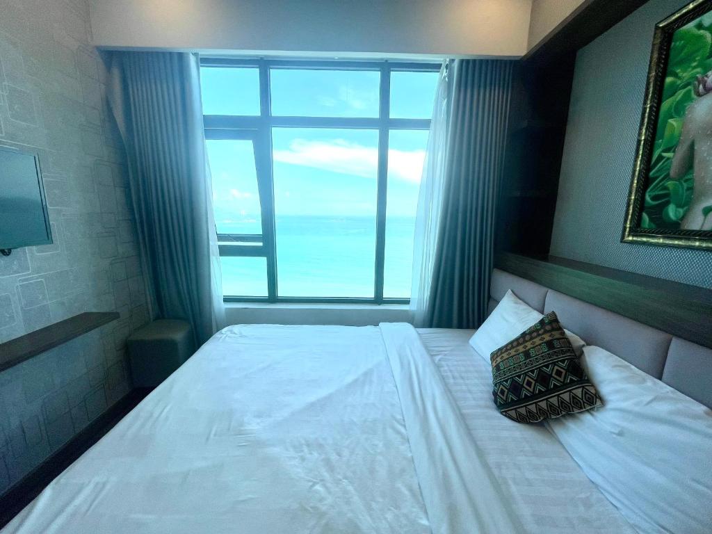 芽庄Muong Thanh Vien Trieu Beachfront Apartment的一间卧室设有一张大床和大窗户