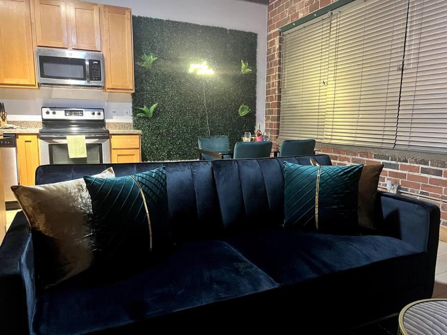 圣路易斯Serene Living Downtown STL Loft的客厅设有蓝色沙发,厨房设有